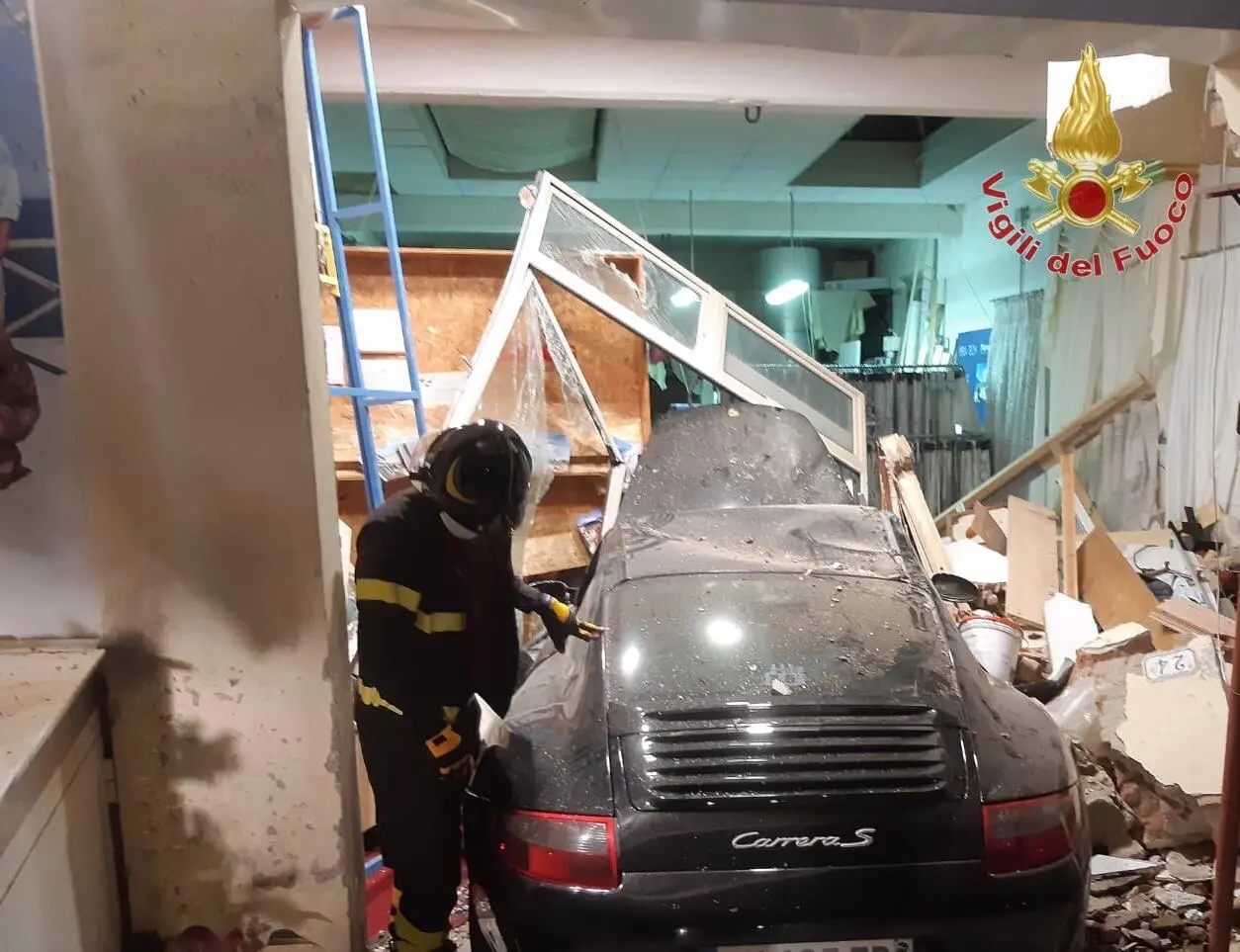 Boato nella notte: Porsche sfonda il portone di un negozio. Due feriti e locale inagibile