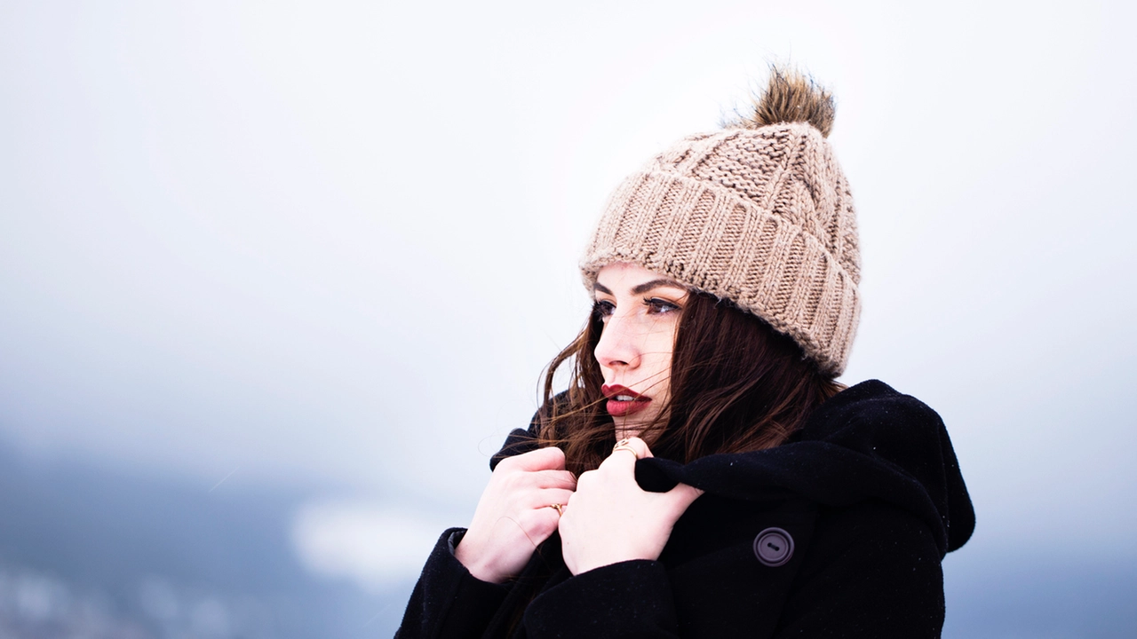 Ragazza si copre dal freddo (Foto d'archivio)