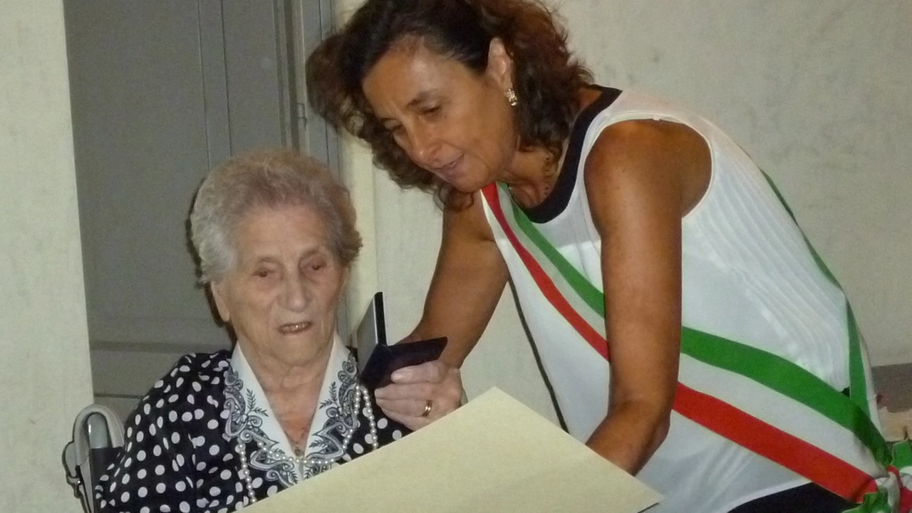 Elide Venturini riceve dalle mani del presidente del consiglio comunale, Ilaria Santi, il gigliato d’argento per i 100 anni raggiunti