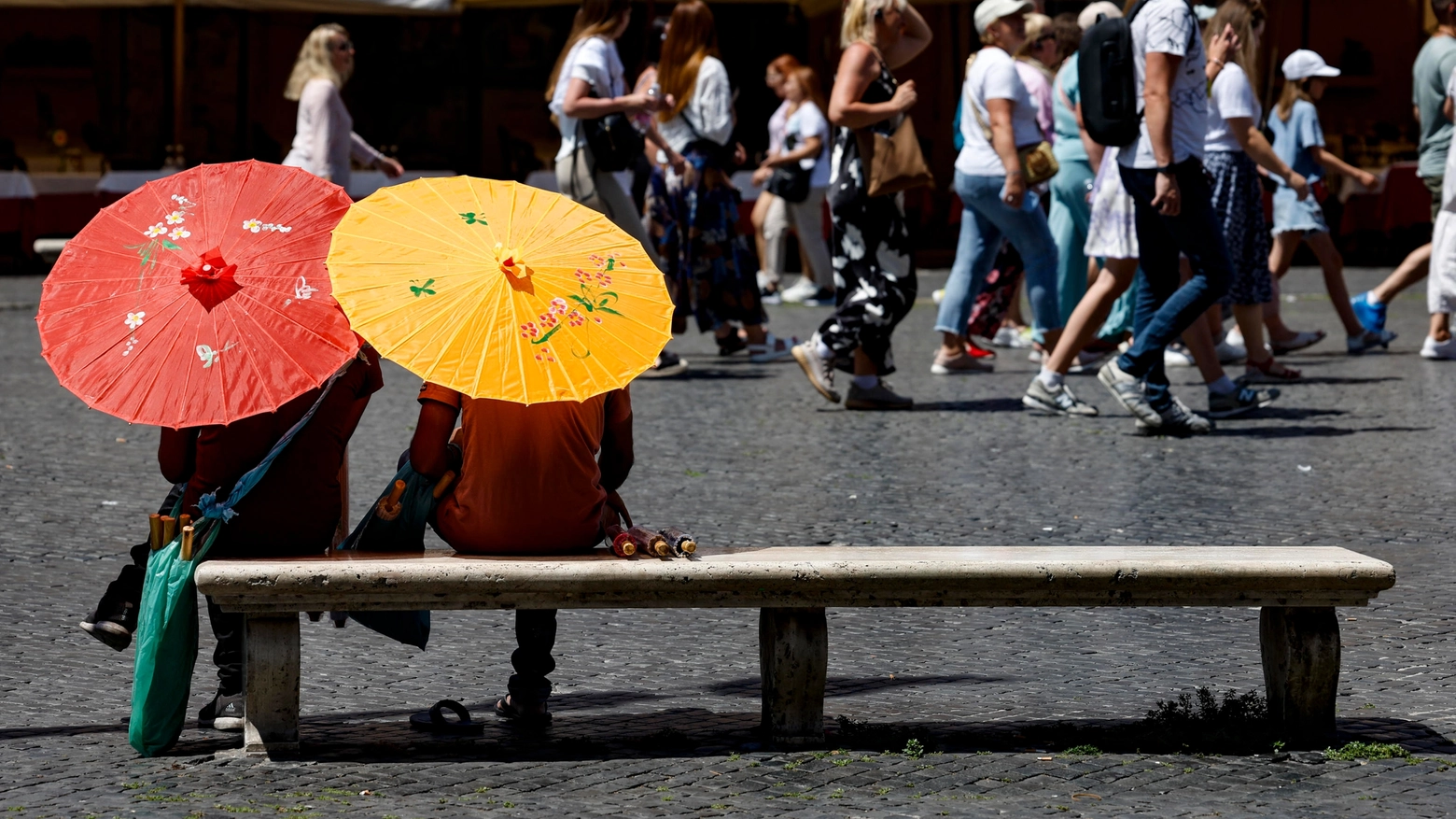 C'è chi ricorre all'ombrellino per ripararsi dal sole (Ansa)