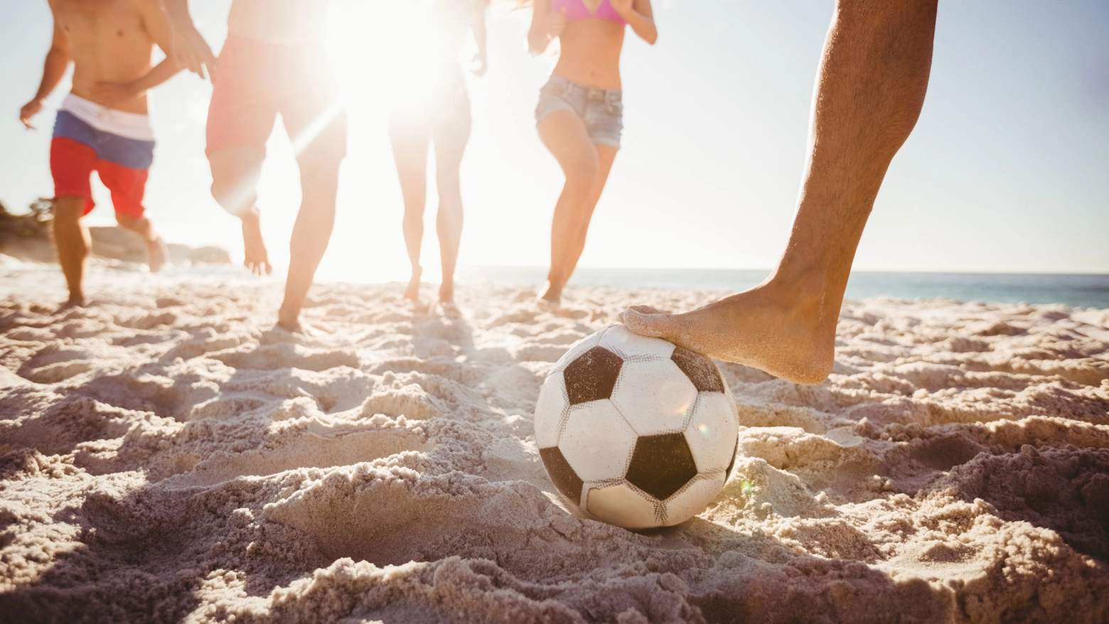 Ragazzi giocano a pallone in spiaggia