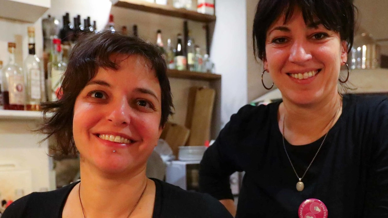 Lucia Cammilli e Laura Pellegrini dietro al bancone del locale Il Campaccio: sulla divisa la spilla contro la violenza (Gasperini/FotocronacheGermogli)