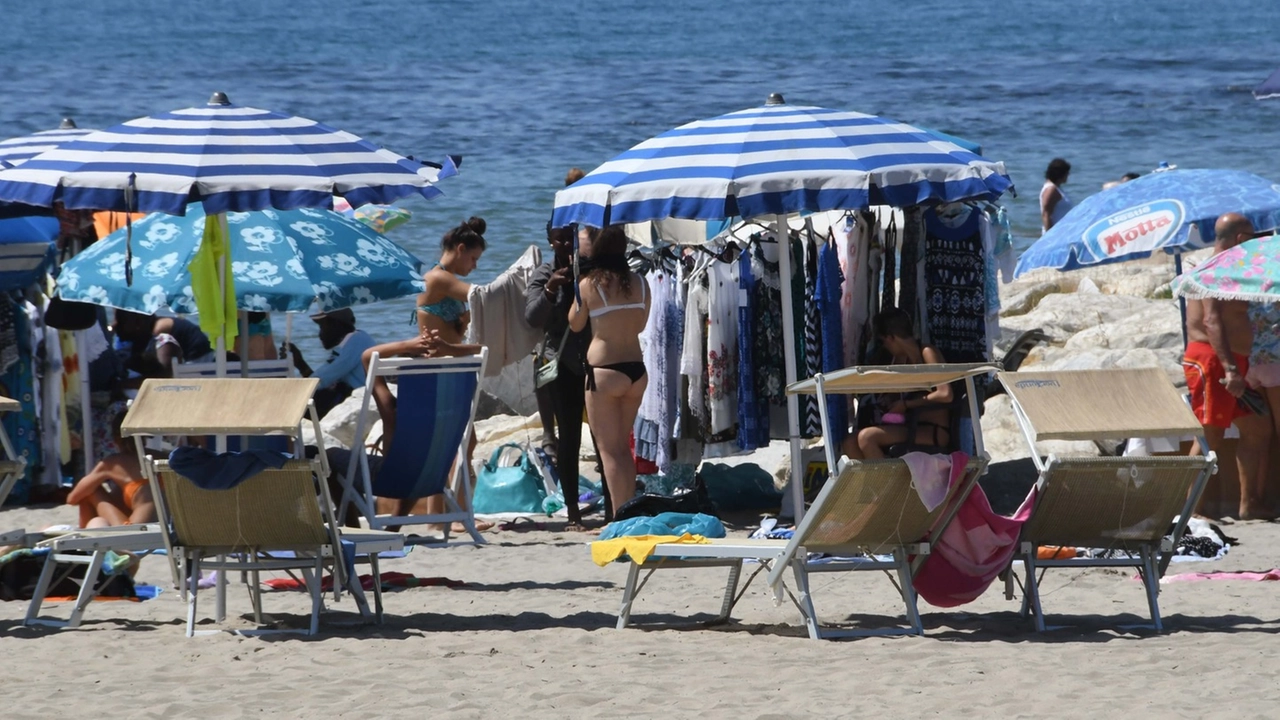 Il mercato abusivo in spiaggia, fotografato sabato: ogni giorno è così