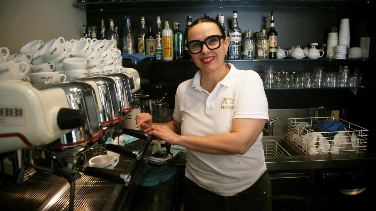 Una barista prepara un espresso alla macchina del caffè