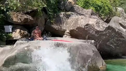 Bagnanti sugli scogli lungo il fiume Frigido a Guardine e la strada che scorre proprio sopra la loro testa