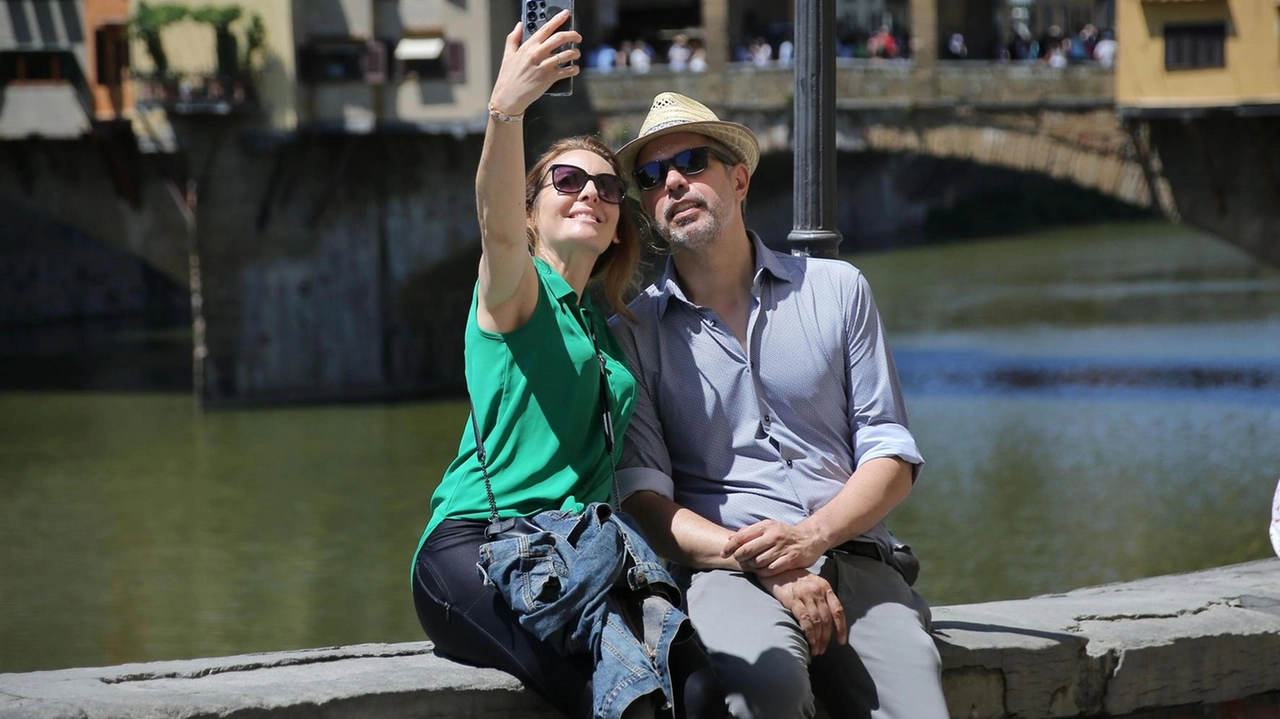 Selfie sulle spallette del lungarno vista Ponte Vecchio. Uno degli scorci preferiti dai turisti che non si fanno mancare lo scatto da condividere