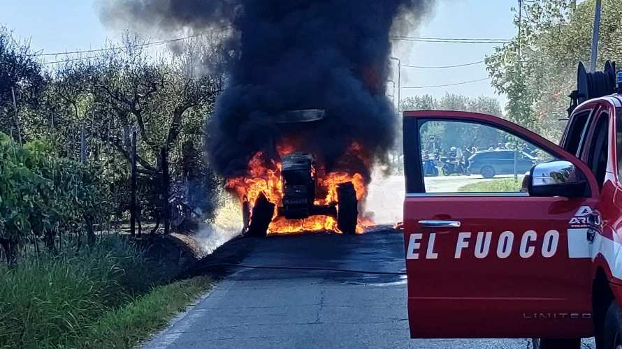 Il trattore avvolto dalle fiamme a Vecchiano con l'intervento dei vigili del fuoco per lo spegnimento