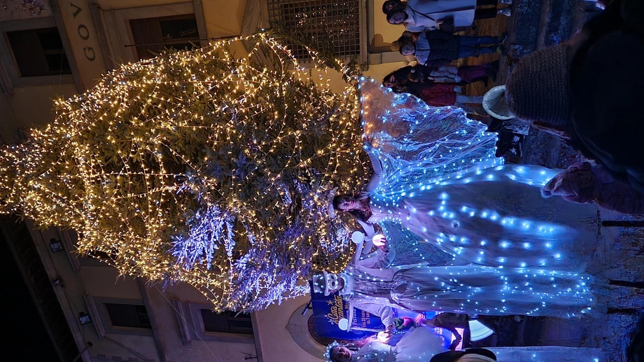 In foto il grande albero di Natale in Piazzo Duomo con le Farfalle Luminose sui trampoli