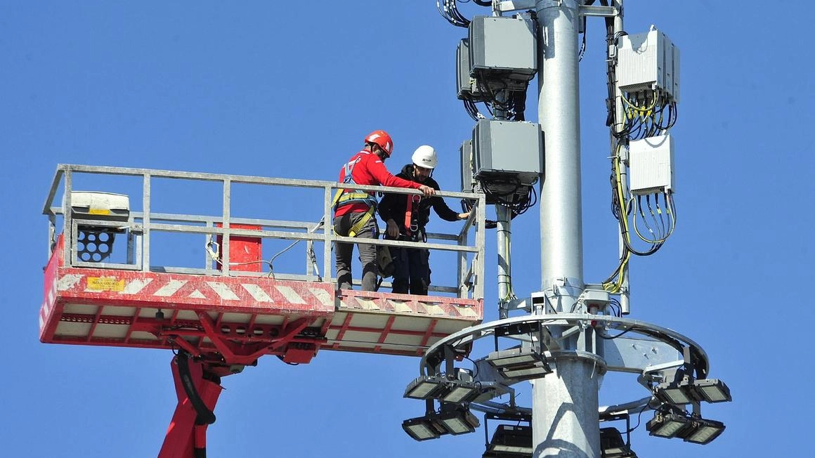 Operai impegnati su una gru per il completamento delle operazioni di installzione di una maxi antenna di telefonia