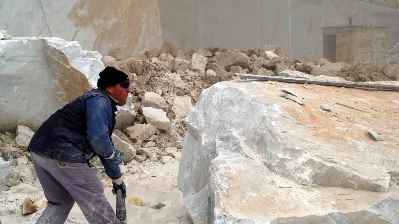 Un lavoratore impegnato in una cava di marmo