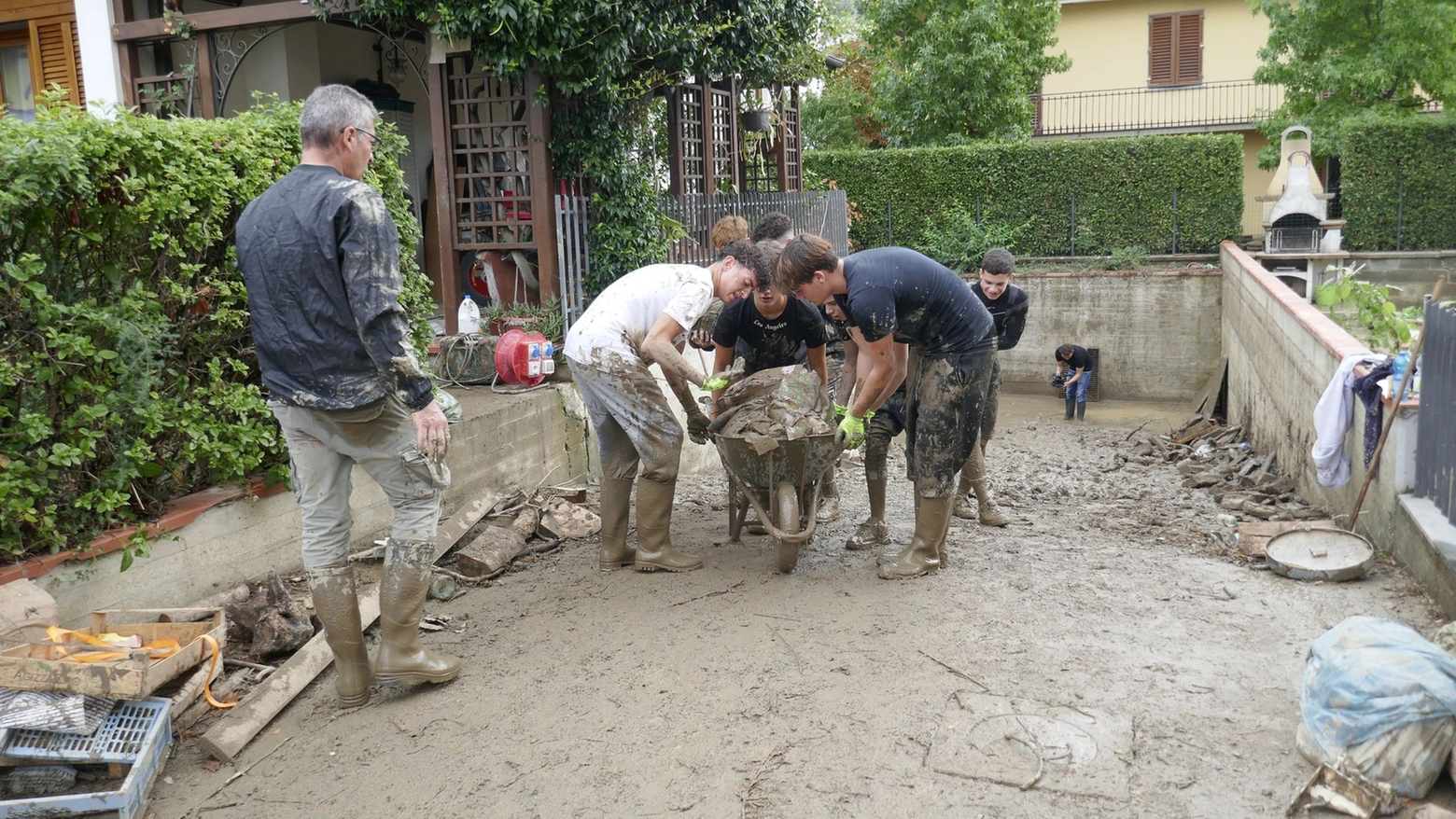 Giovani a spalare a Montemurlo dopo l'esondazione del torrente tombato Stregale