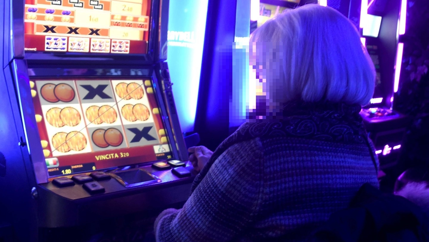 Una signora che gioca alla slot machine