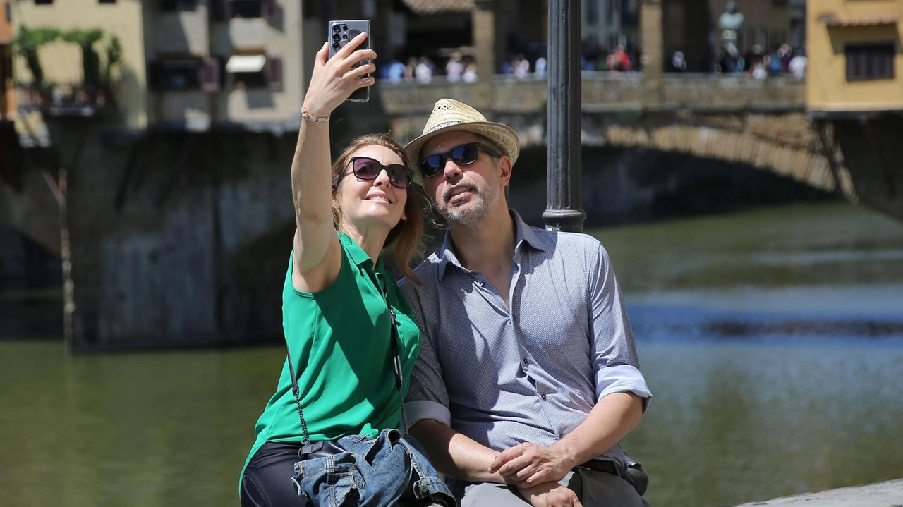 Selfie d’ordinanza per due turisti sulle spallette con il Ponte Vecchio sullo sfondo