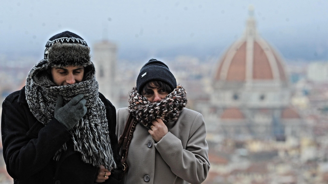 Un uomo e una donna si riparano dal freddo con sciarpe e cappelli a Firenze