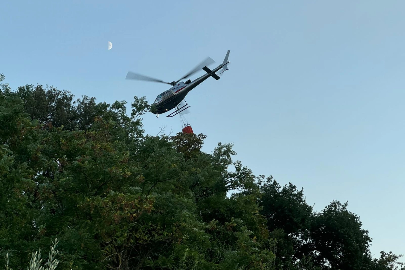 Un elicottero sorvola la zona dell'incendio nel comune di Massa e Cozzile