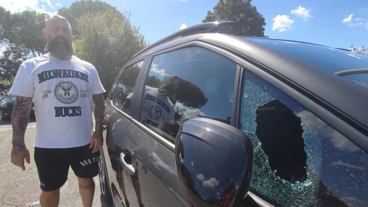 Daniele Cavazzoni mostra il finestrino dell’auto della compagna spaccato nel parcheggio di via Sella. Un mese fa ha subito un tentativo di furto in casa. «Siamo stufi così non ce la facciamo più» Foto Attalmi