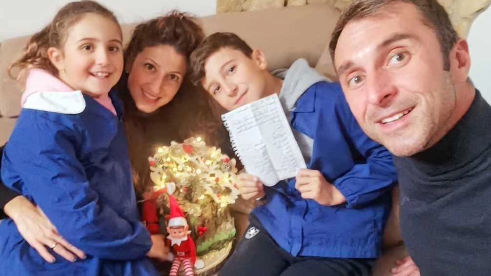 Filippo Donati insieme alla sua famiglia mostra la letterina a Babbo Natale per mantenere il prossimo anno le stesse maestre