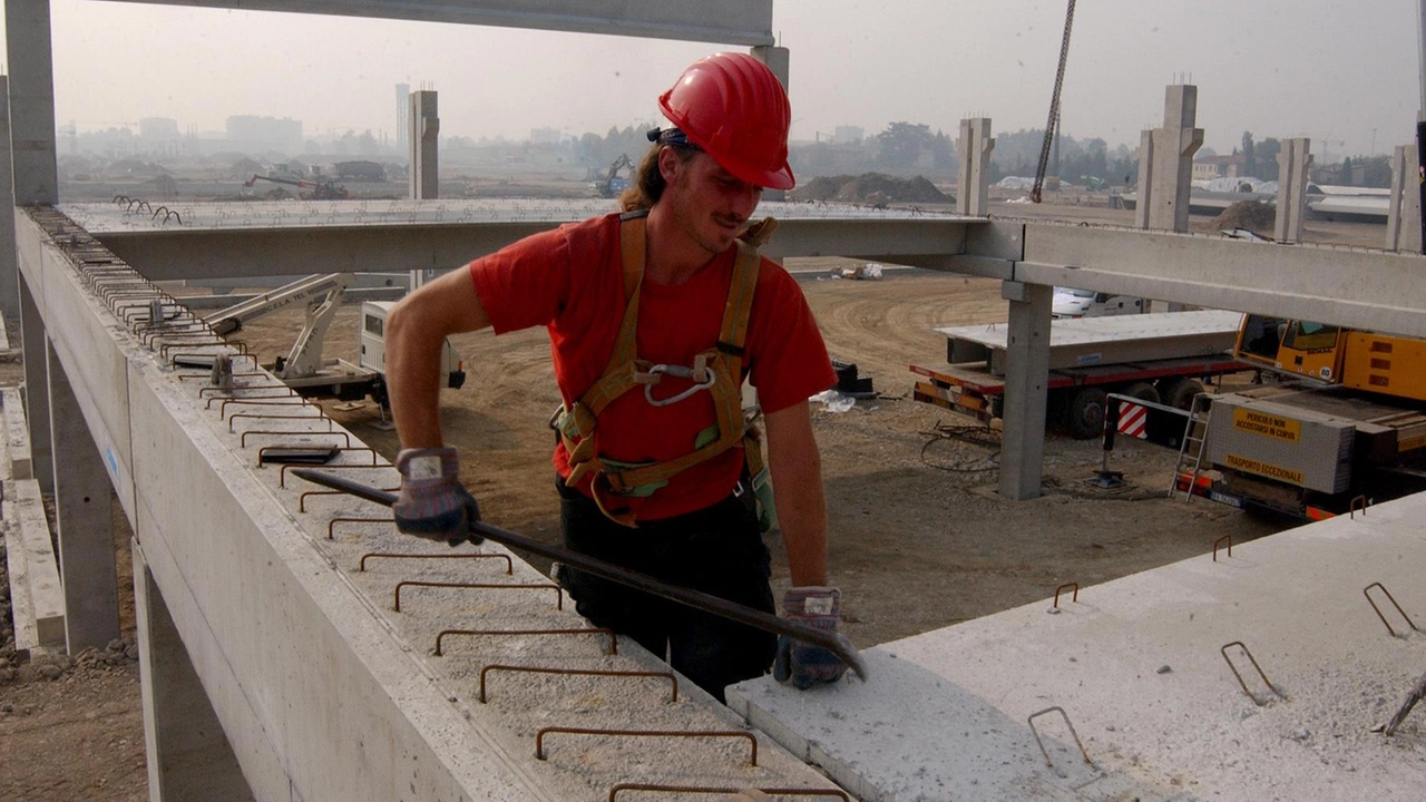 Un operaio al lavoro in un cantiere edile: il tema del consumo del suolo è centrale (foto d’archivio)