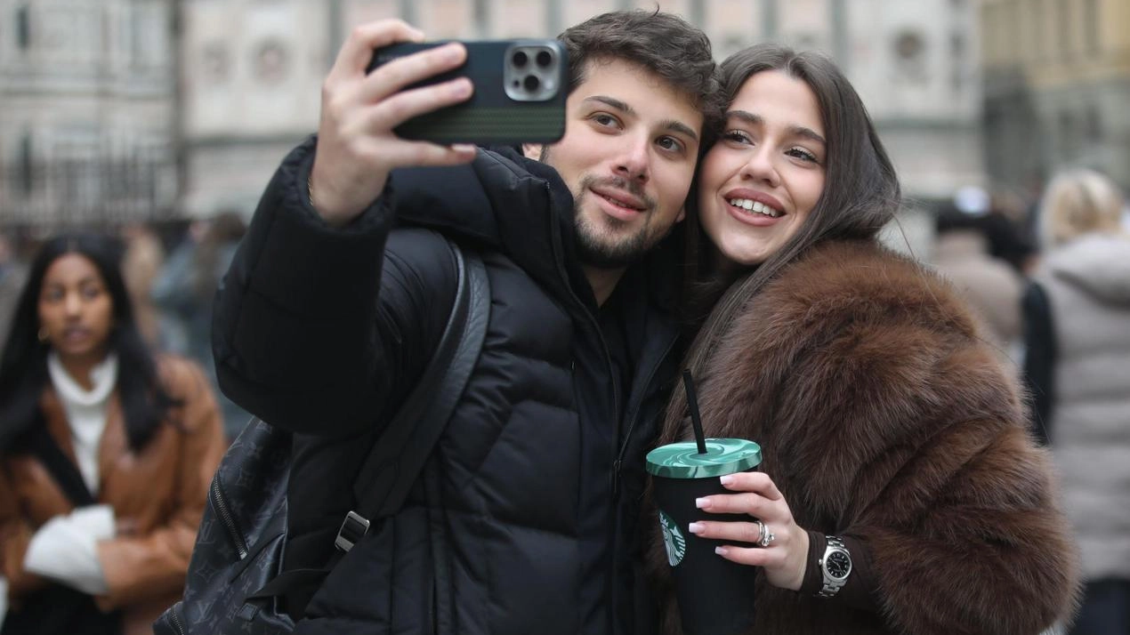 Due turisti si scattano un selfie in piazza Duomo