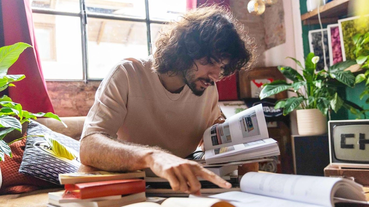 Un giovane intento a leggere alcuni libri (foto Alcide)