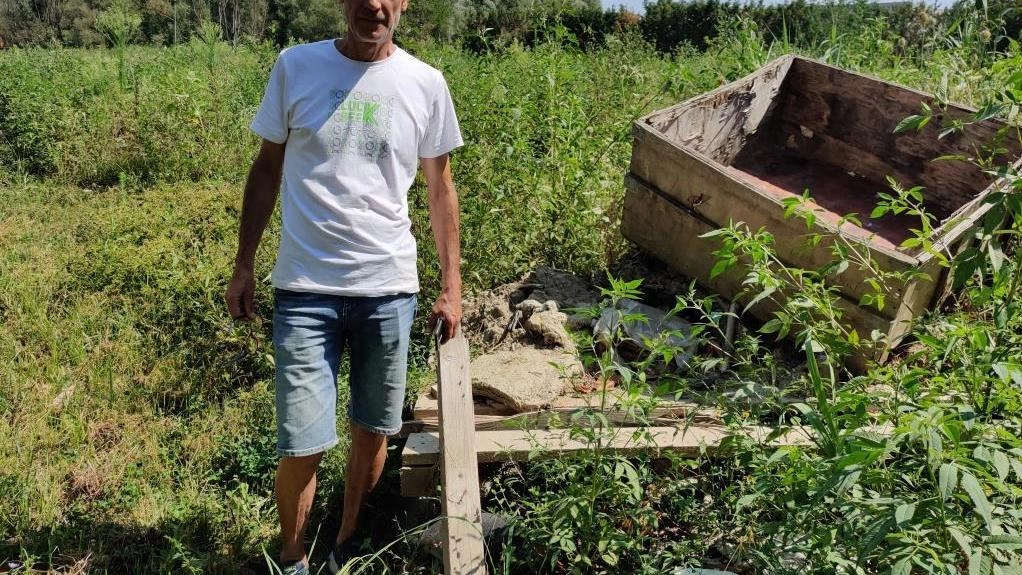 Andrea Gheri accanto a materiali e rifiuti