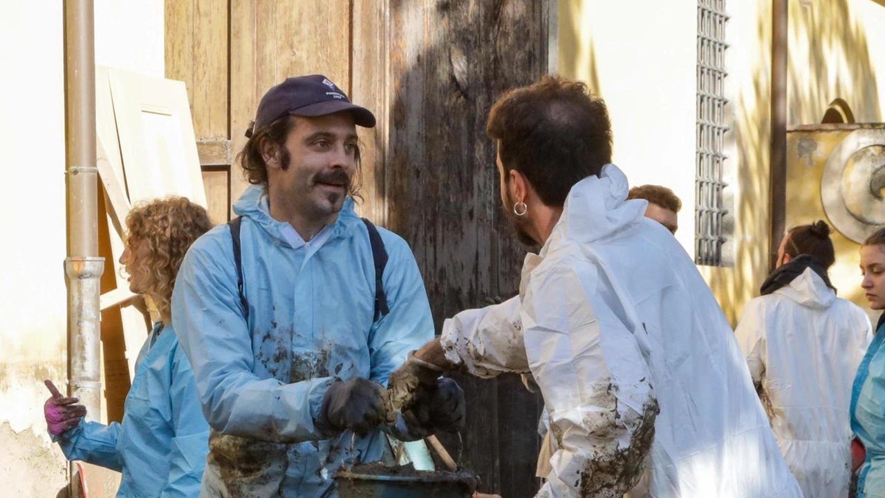 Volontari al lavoro contro il fango che devastò la Toscana. a novembre