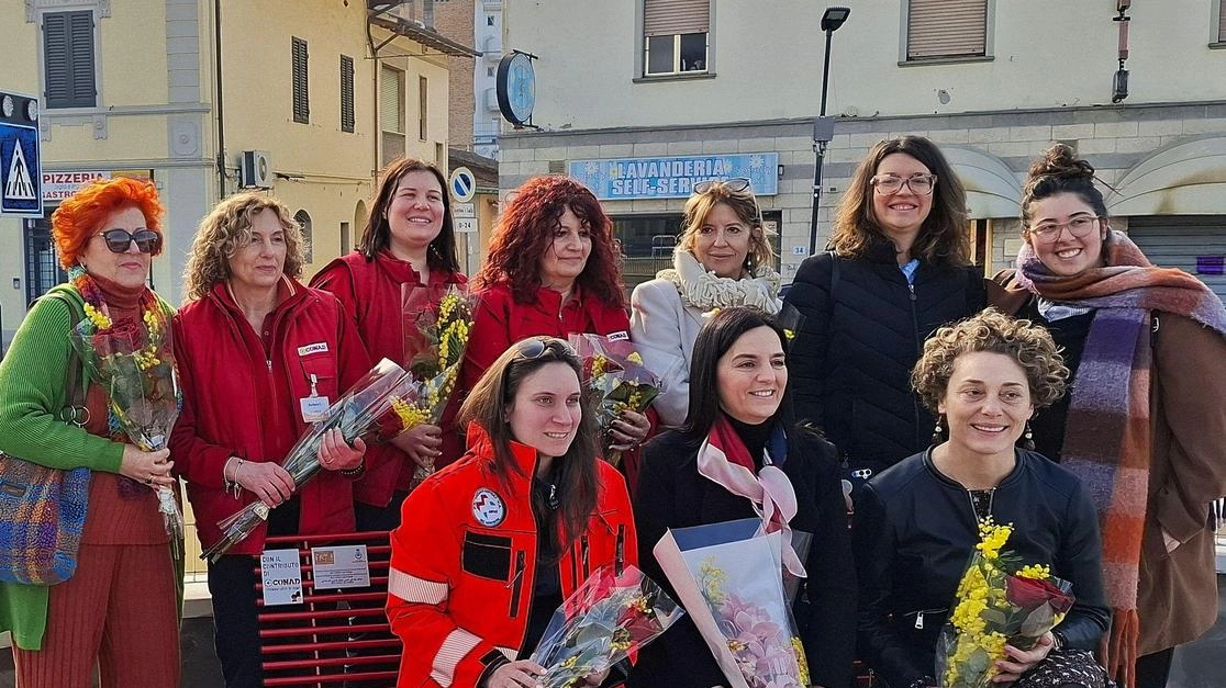 Foto di gruppo sulla panchina rossa con la sindaca e le amministratrici comunali e le collaboratrici di Conad e Frida