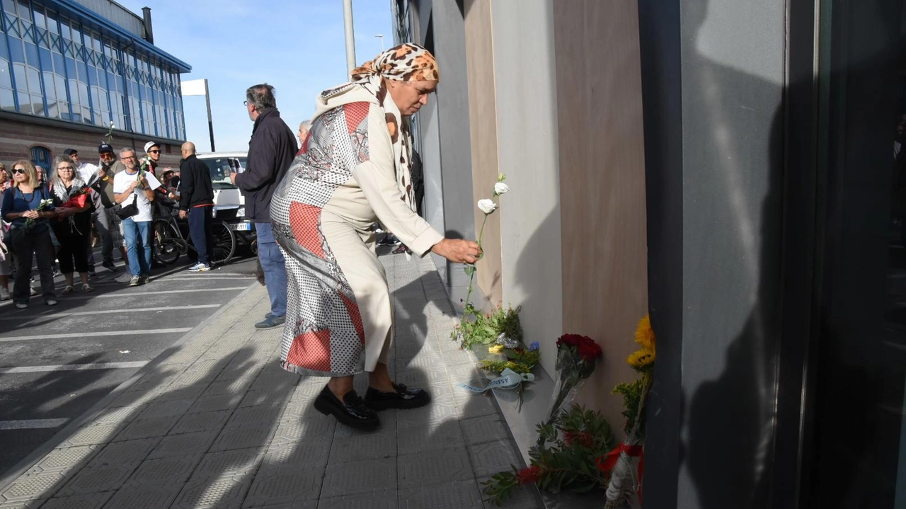 Una donna della comunità marocchina deposita un fiore dove è morto Nouridine