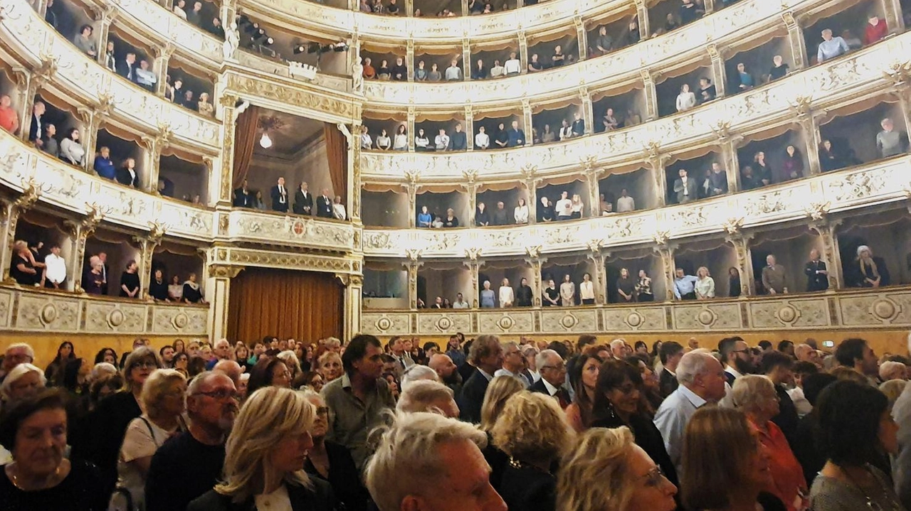 Un interno del Teatro Verdi di Pisa con platea e palchi pieni durante uno spettacolo