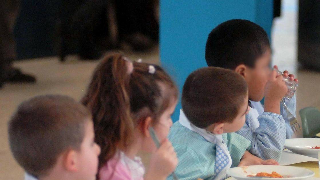 Alcuni piccoli studenti durante un pranzo nella sala mensa di una scuola (foto d’archivio)