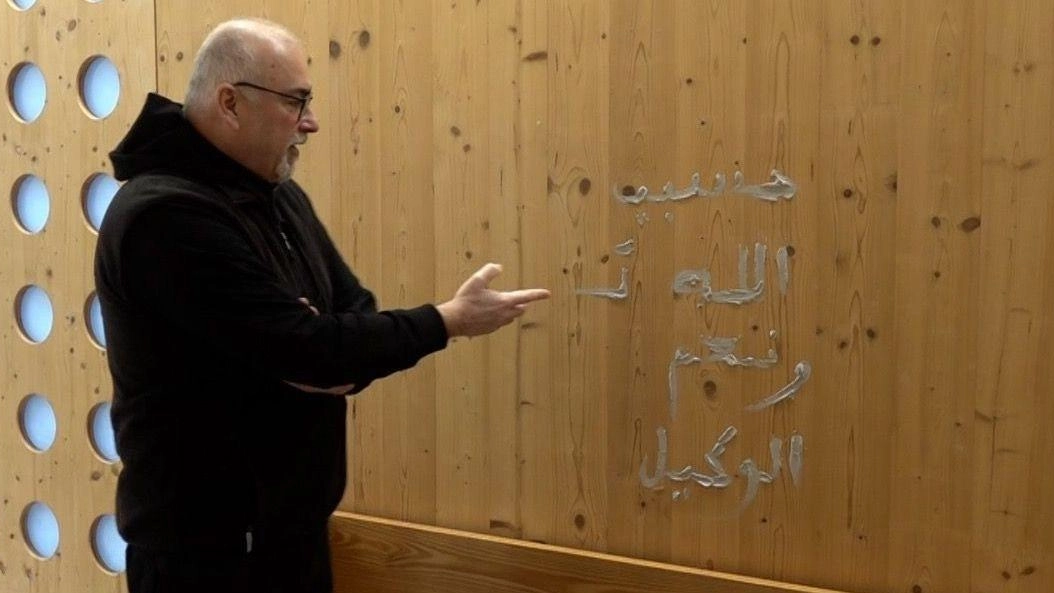 Il parroco don Luca mostra una delle scritte arabe nella chiesa della Resurrezione